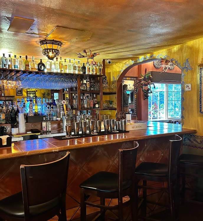 The bar at Vive Sol with tequila bottles and copper light